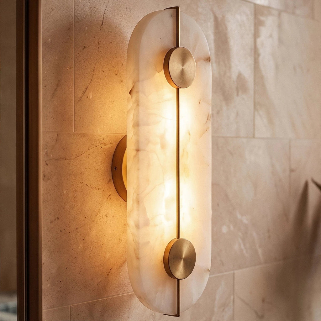 Angled close-up of the Clérachic oval alabaster sconce shows its veining and brass bar against tiled stone.