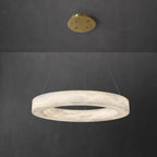 The Clérachic Marika ring on grey, its veined stone band lit softly all the way round.