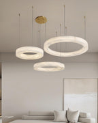 The Clérachic Marika three-ring set lit above a low sofa beside a textured canvas.