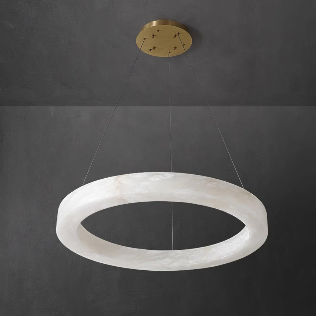 The Clérachic Marika ring on dark grey, brass canopy above the lit alabaster torus.