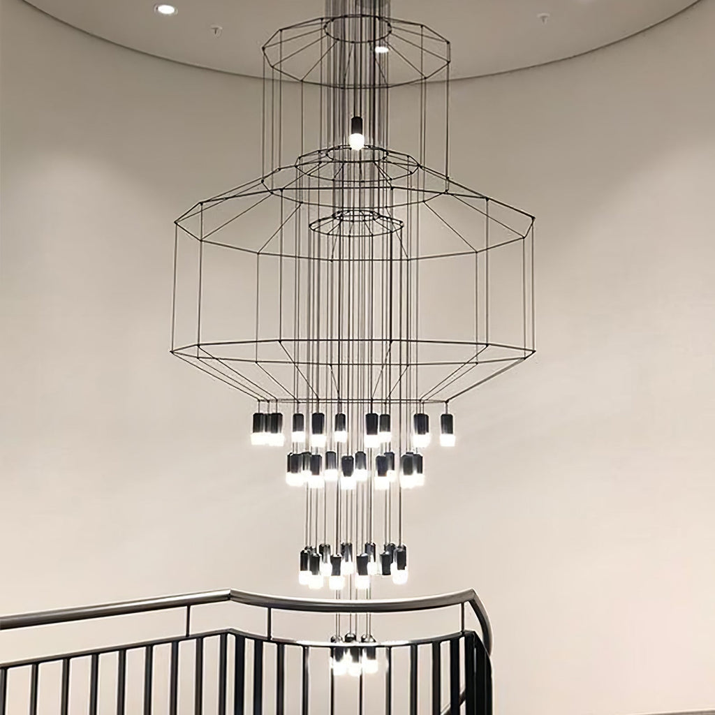 Looking up at a Clérachic chandelier with several octagonal wire frames and many LED drops, seen above a black stair rail.