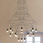 Close view of a wide-flared Clérachic wire chandelier with a ring of lit LED terminals hanging at varied heights.