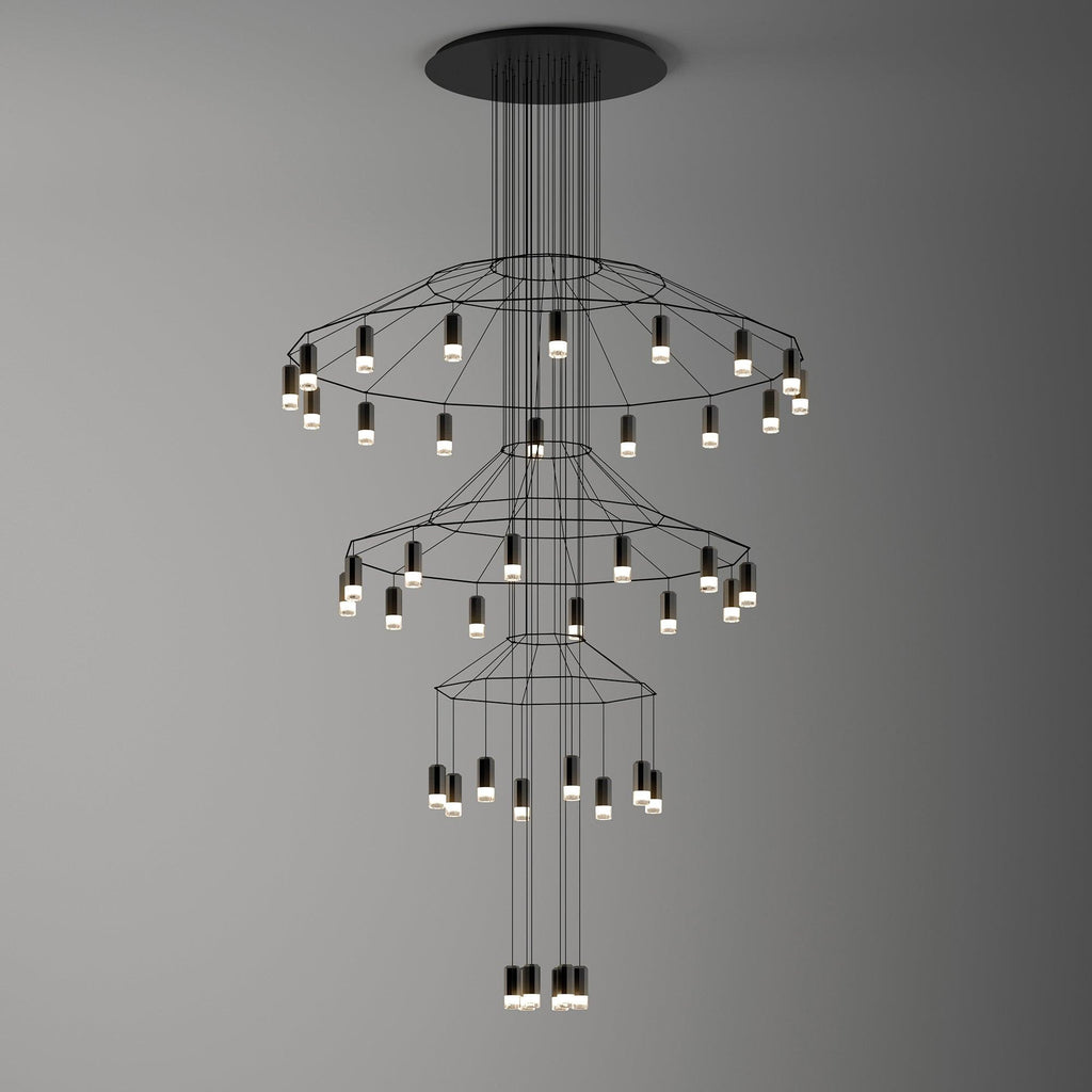 Clérachic wire chandelier on a graduated grey backdrop, with three rings of LED drops stepping down to the centre.