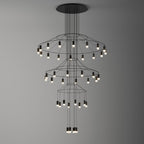 Clérachic wire chandelier on a graduated grey backdrop, with three rings of LED drops stepping down to the centre.