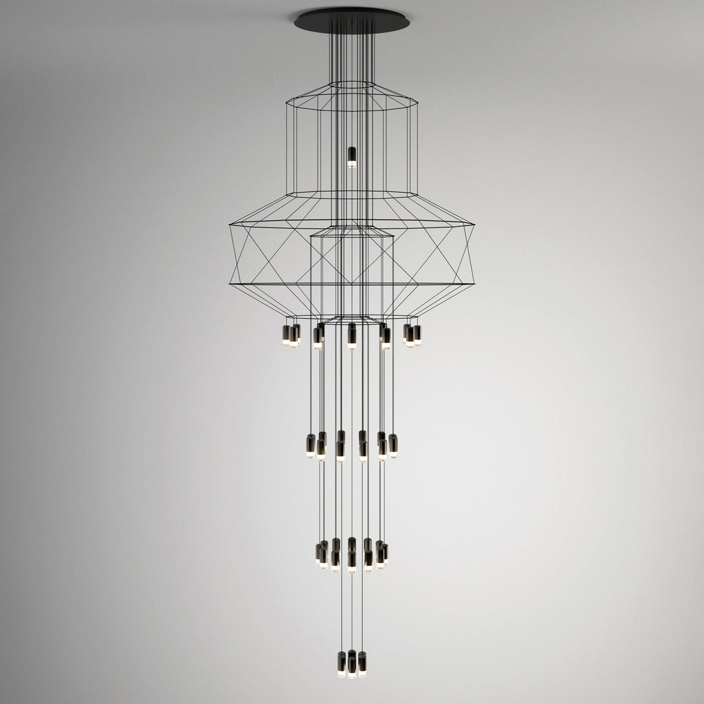 A slim, tall Clérachic wire chandelier with narrow stacked frames and long vertical rows of LED drops, on a grey backdrop.