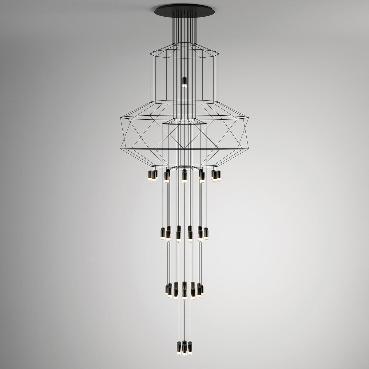 A slim, tall Clérachic wire chandelier with narrow stacked frames and long vertical rows of LED drops, on a grey backdrop.