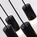 Close view of four matt black cylinder LED drops with frosted lower diffusers on this Clérachic chandelier.