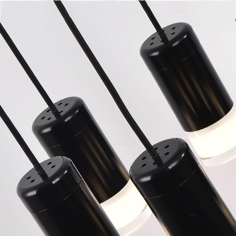 Close view of four matt black cylinder LED drops with frosted lower diffusers on this Clérachic chandelier.