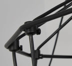 Close view of the black metal rods and small clamp fittings joining the wire frame of this Clérachic chandelier.