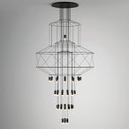 Studio view of the stacked-frame Clérachic wire chandelier with its drops of LED terminals, on a grey backdrop.