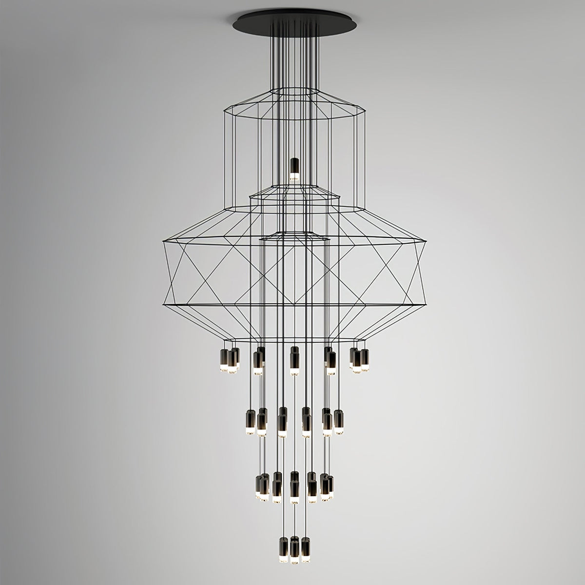 Studio view of the stacked-frame Clérachic wire chandelier with its drops of LED terminals, on a grey backdrop.