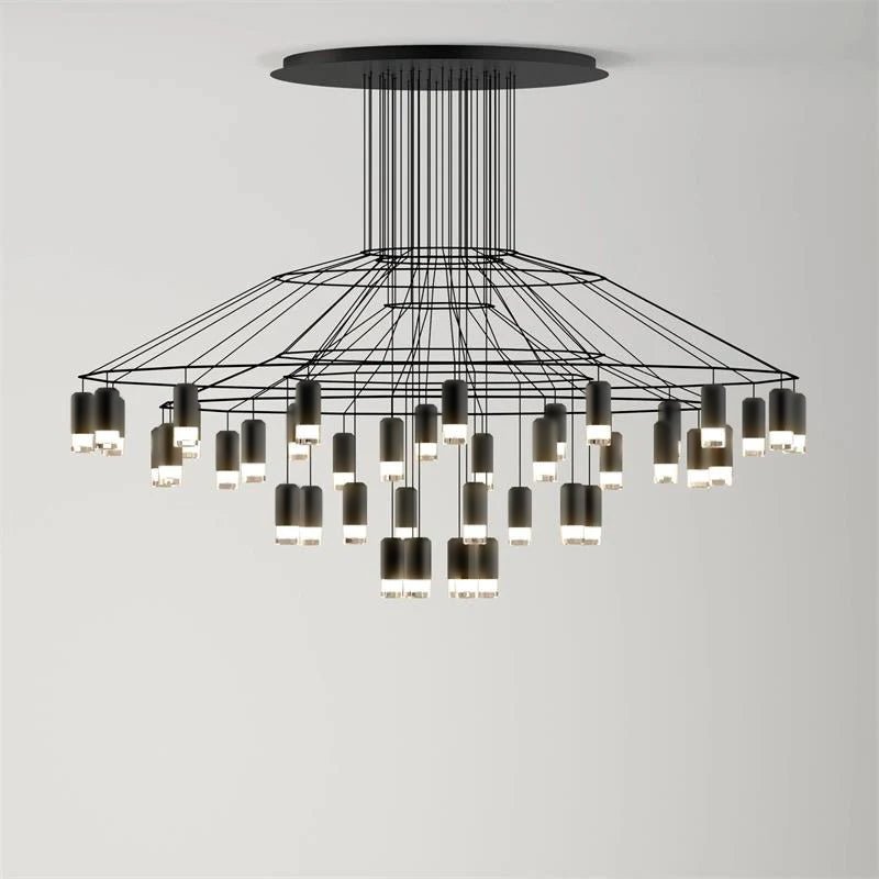 Wide, low Clérachic wire chandelier with a round canopy, thin wires and many LED drops hung at varied heights, on pale grey.