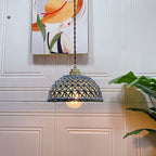 Clérachic pendant light lit, the glow through the shade in a quiet room.