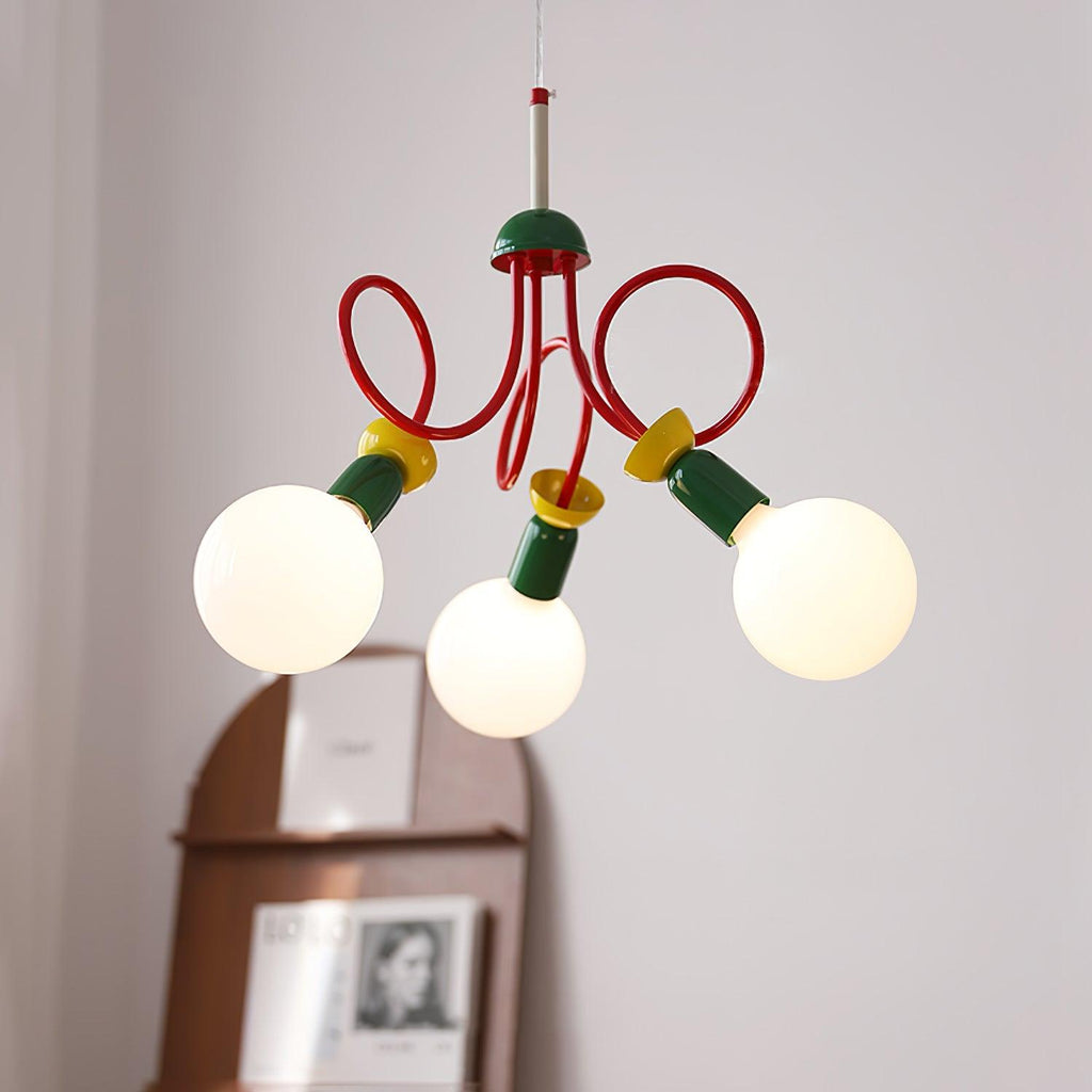 Three globe bulbs on a looping red-armed Clérachic pendant, with an arched wooden shelf and framed print softly out of focus behind.