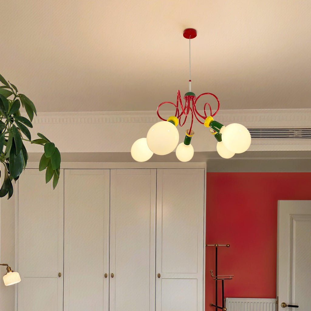 Distant view of this Clérachic pendant glowing high in a room with white cupboards, a red wall and a potted plant.