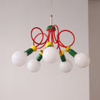 Five white globes hang beneath red looping tubes on this Clérachic pendant, shown against a soft light grey wall.