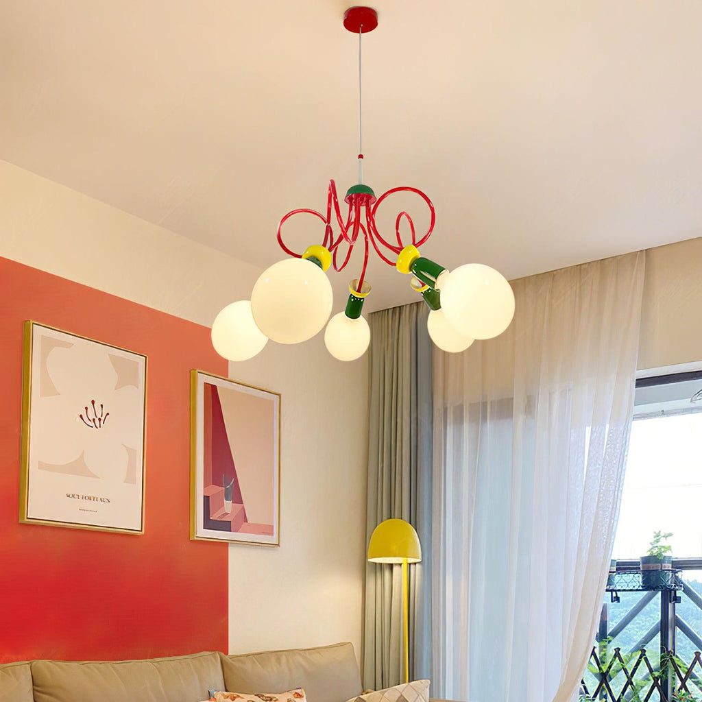This Clérachic pendant hangs in a bright living room with a coral wall, framed prints, a sofa and a yellow lamp.