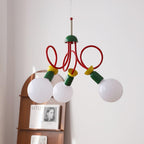 Three globe bulbs and red looping arms of this Clérachic pendant seen close, with an arched shelf and book display behind.