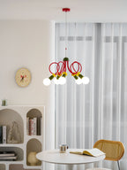 Wide room view of this Clérachic pendant above a round white table and cane chair, with sheer curtains and an arched shelf.