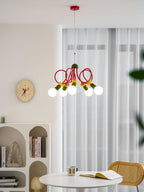 This Clérachic pendant hangs by sheer curtains, with a round wall clock, arched shelving and a cane chair below it.