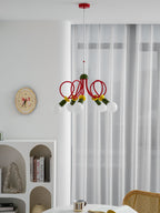 Clérachic pendant with a red ceiling plate, hung in a room with a round clock, an arched white shelf and a cane chair.