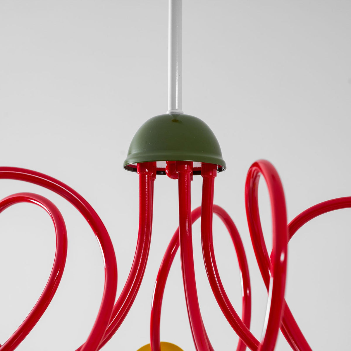 Close view of the green dome cap where the red tubes meet the stem on this Clérachic pendant.
