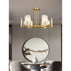 Clérachic Meridian Alabaster Chandelier above a dining table, its six warm heads framed by a round blossom-branch wall piece.