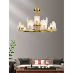 Clérachic Meridian Alabaster Chandelier in the two-tier fifteen-light span, lit against a bare grey wall above a long sofa.