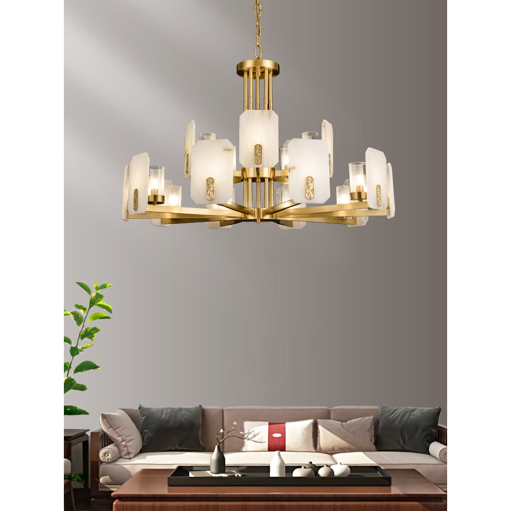 Clérachic Meridian Alabaster Chandelier in the two-tier fifteen-light span, lit against a bare grey wall above a long sofa.