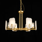 Clérachic Meridian Alabaster Chandelier lit against black, the alabaster panels holding a soft glow behind each clear glass cylinder.
