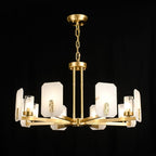 Clérachic Meridian Alabaster Chandelier lit on black with its full chain drop, eight panels ringing the central brass hub.