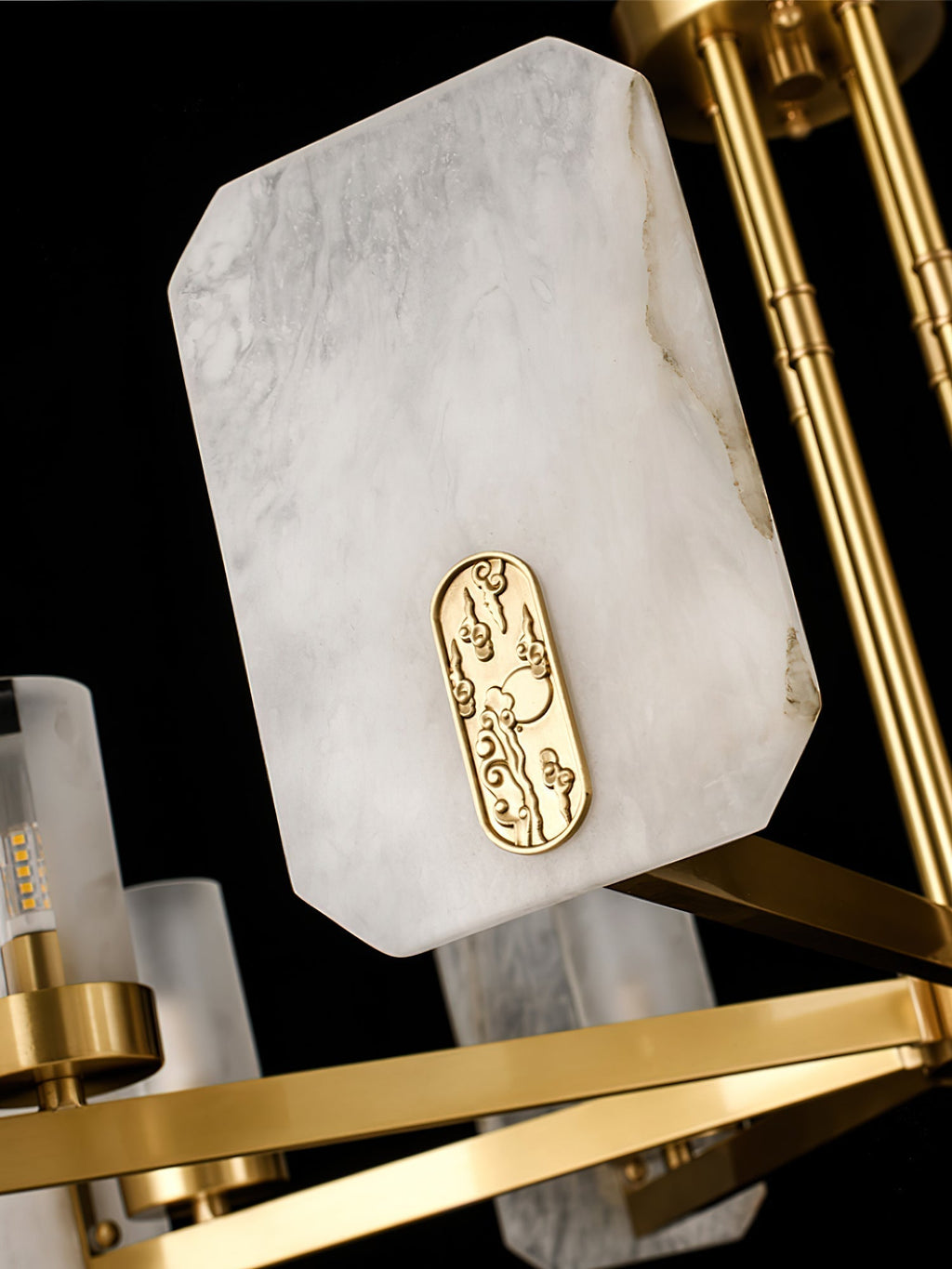 Close-up of a Clérachic Meridian Alabaster Chandelier panel, natural grey-veined stone with a cast brass cloud medallion.