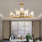 Clérachic Meridian Alabaster Chandelier in fifteen lights, glowing above a sofa and a triptych of grey mountain panels.
