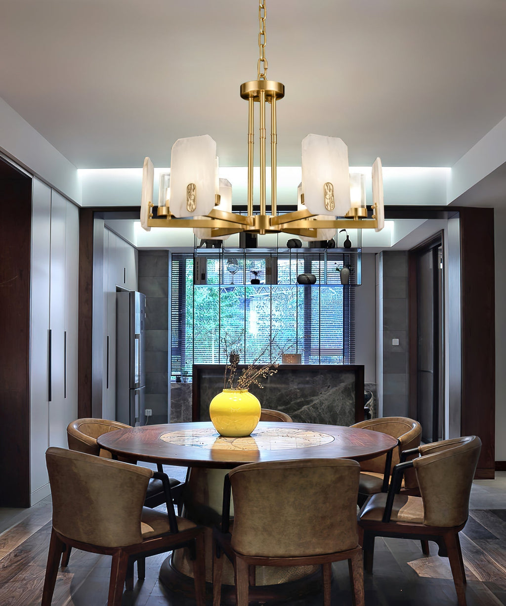 Clérachic Meridian Alabaster Chandelier lit over a round dining table set with a yellow vase, six alabaster panels warm above it.