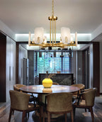 Clérachic Meridian Alabaster Chandelier lit over a round dining table set with a yellow vase, six alabaster panels warm above it.