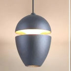 Clérachic textured charcoal acorn pendant showing a gold interior and a thin black cord.
