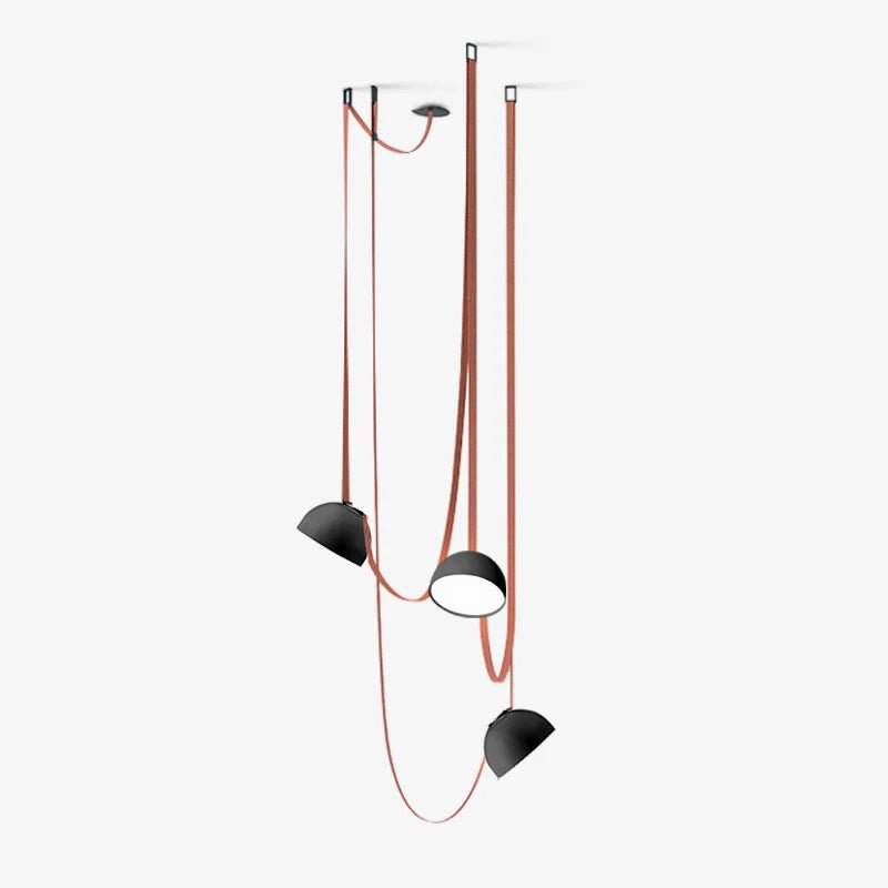 Three black-domed Clérachic pendant lights hang at different heights from red woven straps, on a pale grey studio backdrop.
