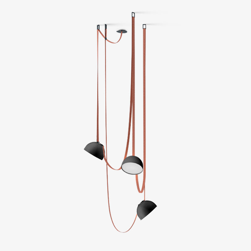 Another view of the three-head Clérachic pendant light with black domes and red woven straps, one shade turned to show its glowing underside.
