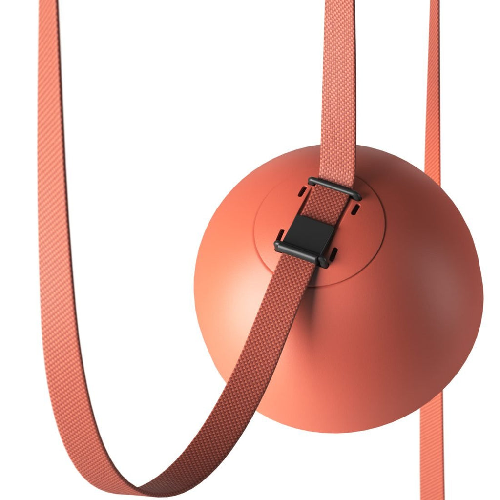 Close view of the buckle and woven red strap crossing an orange dome on this Clérachic pendant light.