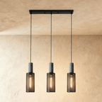 Clérachic linear pendant with three slim mesh cylinders on a black bar canopy, each lit by a filament bulb