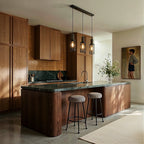 Clérachic linear three-head pendant with mesh cylinders hung over a green stone kitchen island with two stools