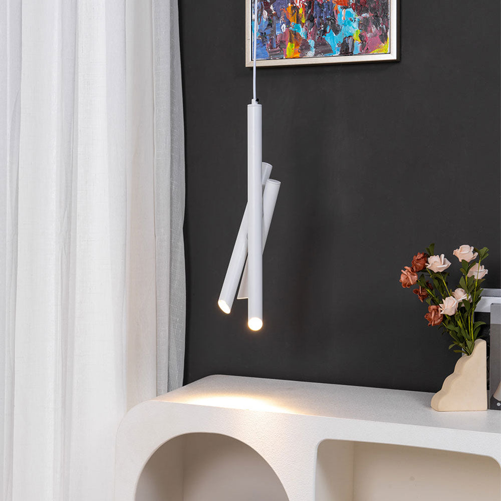 Clérachic white three-drop metal tube pendant glowing over a white console, dark wall, curtain, and a vase of roses.