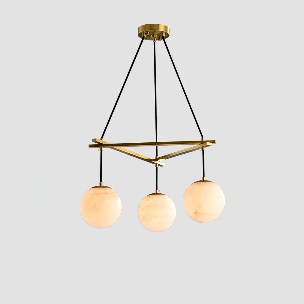 Clérachic Miira chandelier with three alabaster orbs on a slim brass frame.