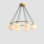 Clérachic Miira chandelier with six orbs, seen level so the brass frame reads clearly.