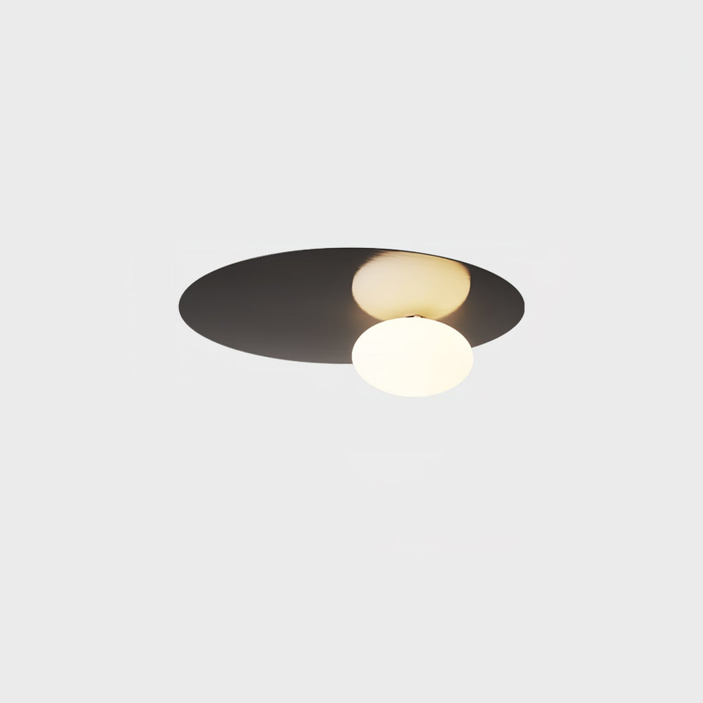Black Clérachic ceiling light with a lit glass globe against a pale grey background, viewed from the side.