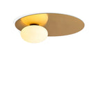 Brass Clérachic ceiling light, the glass globe glowing warm against the disc, cut out on a white background.