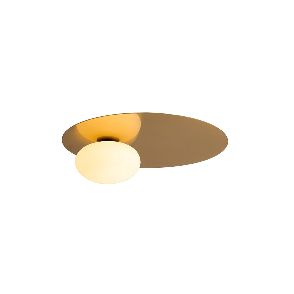 Brass Clérachic ceiling light with a lit glass globe, cut out on a white background and seen from below.