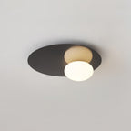 Black Clérachic ceiling light with a lit globe, with the disc shape clear against a light grey ceiling.