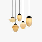 Clérachic milk glass pendant light shade profiles lined up on black cords at staggered drops on a plain white background.