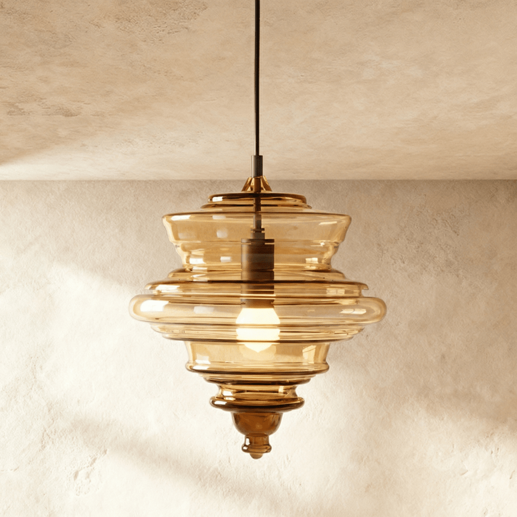 Clérachic's pendant light in cognac glass, a tiered ribbed shade glowing warm on a dark cord overhead.